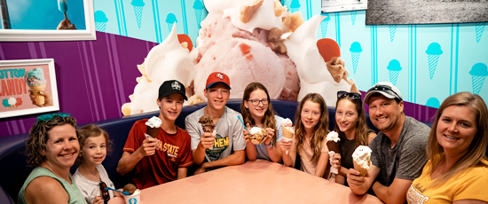 Group of people holding ice cream cones smiling for the camera